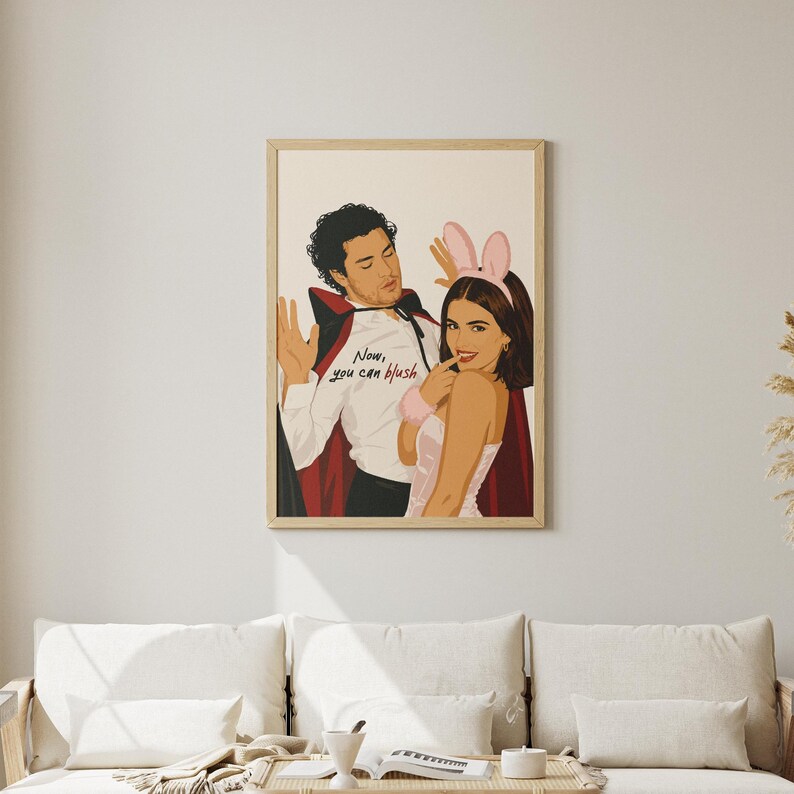 Stylized digital wall art featuring a romantic college couple inspired by a popular sports romance book series. The artwork shows a dark-haired male character dressed in a playful vampire costume beside a smiling female character wearing pink bunny ears. The illustration includes the quote "Now, you can blush" and is rendered in a modern minimalist portrait style with clean lines and soft colors. Perfect for romance readers, book lovers, and contemporary literary-inspired home decor.