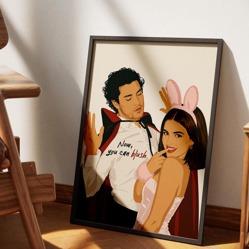Stylized digital wall art featuring a romantic college couple inspired by a popular sports romance book series. The artwork shows a dark-haired male character dressed in a playful vampire costume beside a smiling female character wearing pink bunny ears. The illustration includes the quote "Now, you can blush" and is rendered in a modern minimalist portrait style with clean lines and soft colors. Perfect for romance readers, book lovers, and contemporary literary-inspired home decor.