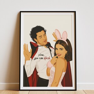 Stylized digital wall art featuring a romantic college couple inspired by a popular sports romance book series. The artwork shows a dark-haired male character dressed in a playful vampire costume beside a smiling female character wearing pink bunny ears. The illustration includes the quote "Now, you can blush" and is rendered in a modern minimalist portrait style with clean lines and soft colors. Perfect for romance readers, book lovers, and contemporary literary-inspired home decor.