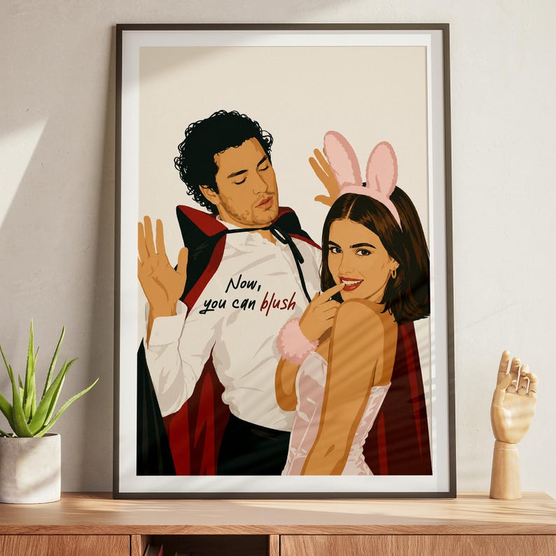 Stylized digital wall art featuring a romantic college couple inspired by a popular sports romance book series. The artwork shows a dark-haired male character dressed in a playful vampire costume beside a smiling female character wearing pink bunny ears. The illustration includes the quote "Now, you can blush" and is rendered in a modern minimalist portrait style with clean lines and soft colors. Perfect for romance readers, book lovers, and contemporary literary-inspired home decor.