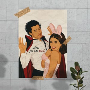 Stylized digital wall art featuring a romantic college couple inspired by a popular sports romance book series. The artwork shows a dark-haired male character dressed in a playful vampire costume beside a smiling female character wearing pink bunny ears. The illustration includes the quote "Now, you can blush" and is rendered in a modern minimalist portrait style with clean lines and soft colors. Perfect for romance readers, book lovers, and contemporary literary-inspired home decor.
