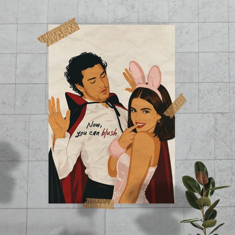 Stylized digital wall art featuring a romantic college couple inspired by a popular sports romance book series. The artwork shows a dark-haired male character dressed in a playful vampire costume beside a smiling female character wearing pink bunny ears. The illustration includes the quote "Now, you can blush" and is rendered in a modern minimalist portrait style with clean lines and soft colors. Perfect for romance readers, book lovers, and contemporary literary-inspired home decor.