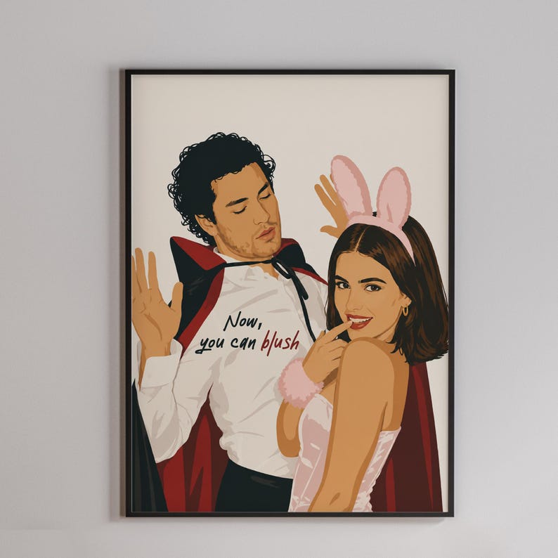 Stylized digital wall art featuring a romantic college couple inspired by a popular sports romance book series. The artwork shows a dark-haired male character dressed in a playful vampire costume beside a smiling female character wearing pink bunny ears. The illustration includes the quote "Now, you can blush" and is rendered in a modern minimalist portrait style with clean lines and soft colors. Perfect for romance readers, book lovers, and contemporary literary-inspired home decor.