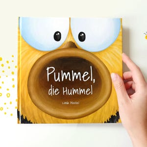 Könnte beinhalten: Ein gelbes Buch mit einer Comic-Illustration einer Biene mit großen Augen und einer großen braunen Honigwabe auf dem Cover. Der Titel des Buches lautet "Pummel, die Hummel" von Linda Merkel.