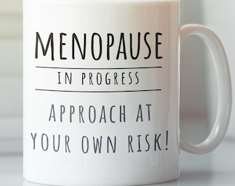 May include: White ceramic mug with black text that reads "Menopause in progress. Approach at your own risk!"