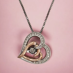 10 Karat gold heart and sterling silver with happy diamond accent and created white topaz detail.