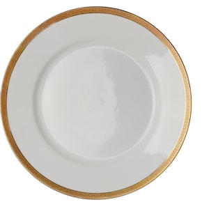 Puede incluir: Un plato llano redondo de color blanco con un borde ancho decorado con un patrón de greca griega en color dorado metálico. El centro del plato es de color blanco liso con un acabado brillante y el borde exterior tiene un diseño geométrico.