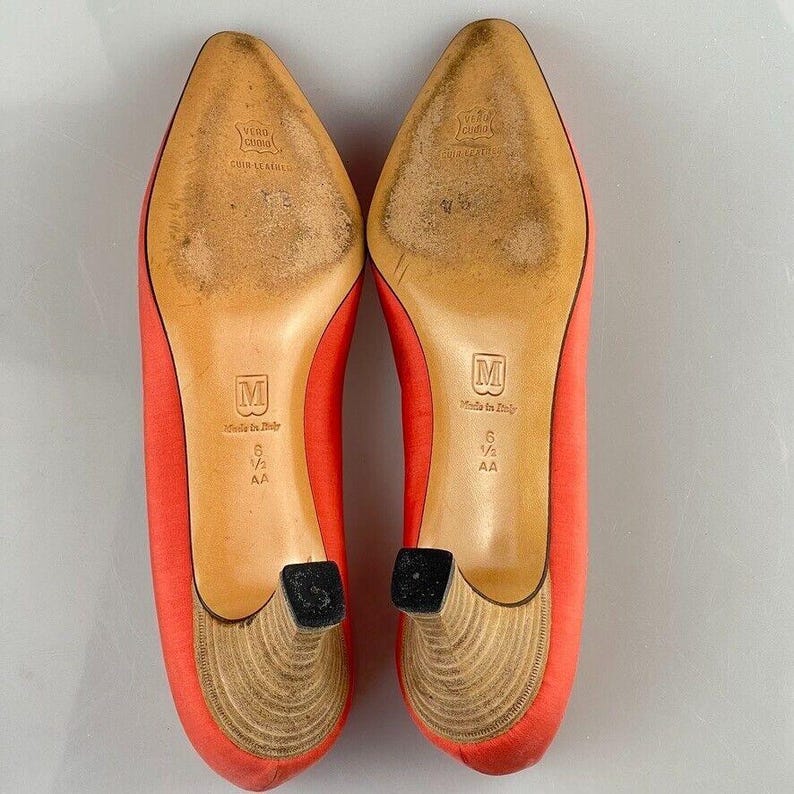 May include: A pair of red satin high heels with a wooden heel. The shoes are size 6 1/2 AA and are made in Italy.