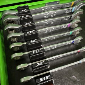 May include: A set of silver combination wrenches, organized in a black holder. Each wrench is labeled with its size in inches, ranging from 5/16" to 3/4". The wrenches have the "Wera" and "Joker" brand names.