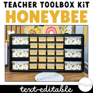 May include: A black plastic storage box with clear drawers labeled with white text. The drawers are filled with various classroom supplies, such as pens, paper clips, white out, magnets, staples, erasers, tape, and more. The box has a honeybee theme with a yellow and black pattern on the front. The text "TEACHER TOOLBOX KIT HONEYBEE" is written in yellow letters on the top of the box. The text "text-editable" is written in black letters at the bottom of the image.