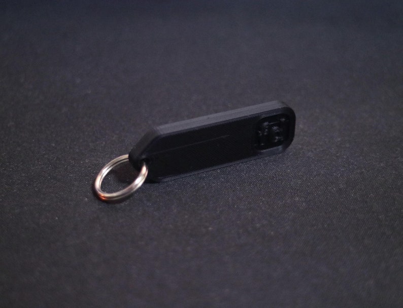 May include: A black plastic key chain with a silver metal ring.