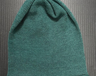 Berretto morbido lavorato a mano in lana merino verde, con trecce.