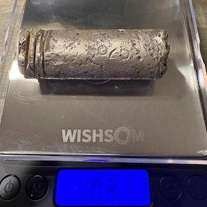 May include: A cylindrical, textured silver-colored metal ingot with the stamped number 925 on its surface, resting on a digital scale that displays a weight of 10.31 ounces. The scale features a blue backlit screen and the brand name WISHSOM.