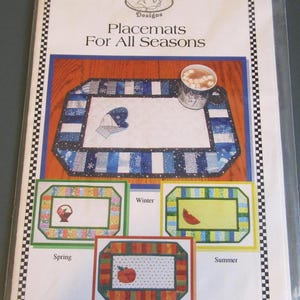 Puede incluir: Un paquete de manteles individuales para todas las estaciones. El mantel individual principal tiene un tema de invierno azul y blanco con un diseño de mitón y copo de nieve. Manteles individuales adicionales muestran temas de primavera, verano y otoño.