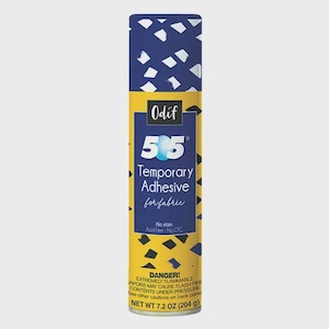 May include: A cylindrical can of Odif 505 Temporary Adhesive for fabric. The can has a blue and white patterned top, a yellow and blue label with the product name, and a warning label. Net weight is 204 g.