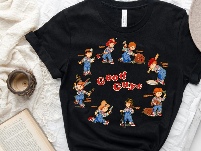 May include: Black t-shirt with a graphic of eight Good Guys dolls from the Child's Play movie franchise. Each doll is depicted in a different pose, holding a tool or weapon. The text "Good Guys" is printed in red and white letters.