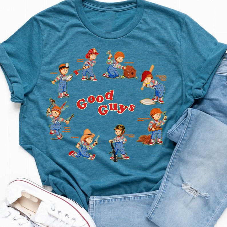 May include: A teal blue t-shirt with a graphic print of various cartoon characters in different poses. The characters are all wearing overalls and have red hair. The text "Good Guys" is printed in red letters below the characters.