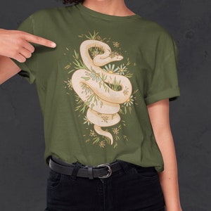 May include: A green t-shirt with a white snake wrapped around a cluster of white and yellow flowers. The snake is curled up and has a crown of flowers on its head.
