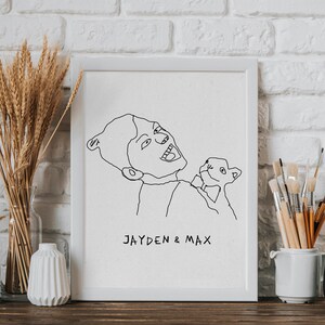 K&ouml;nnte beinhalten: Eine Schwarzwei&szlig;-Zeichnung einer Person, die ein kleines Tier h&auml;lt. Die Zeichnung ist in einem wei&szlig;en Rahmen gerahmt und der Text "JAYDEN & MAX" steht unter der Zeichnung.