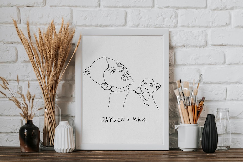 K&ouml;nnte beinhalten: Eine Schwarzwei&szlig;-Zeichnung einer Person, die ein kleines Tier h&auml;lt. Die Zeichnung ist in einem wei&szlig;en Rahmen gerahmt und der Text "JAYDEN & MAX" steht unter der Zeichnung.