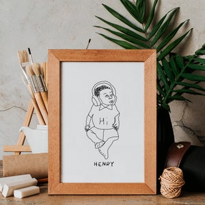 K&ouml;nnte beinhalten: Eine gerahmte Schwarzwei&szlig;-Zeichnung eines Babys mit Kopfh&ouml;rern und einem Shirt mit der Aufschrift "Hi". Der Name des Babys, "HENRY", steht unter der Zeichnung.