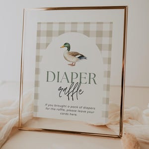 May include: A white sign with a brown and white gingham pattern border. The sign has a picture of a duck and the text "DIAPER raffle" in black. The text below the picture says "If you brought a pack of diapers for the raffle, please leave your cards here."