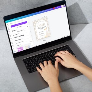 May include: A laptop computer with a white screen displaying a design for a birthday party invitation. The design features a white goose with a gold crown and the text "Celebrating One Silly Goose". The text "Welcome to Sophia's 1st Birthday" is also included in the design.