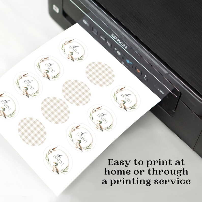 May include: A sheet of printable baby shower stickers with a duck and reeds design. The stickers are round and have a gingham pattern. The text on the stickers reads "It's a Baby!"