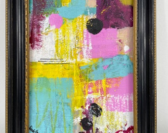 May include: Abstract painting in a black frame with a gold trim. The painting features a mix of pink, yellow, blue, and black paint. The artist's signature, "Linda Blackley", is visible in the bottom left corner.
