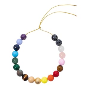 Op de afbeelding: Een regenboogkleurige kralenketting met een gouden koord. De kralen zijn gemaakt van verschillende soorten stenen, waaronder amethist, turquoise en tijgeroog.