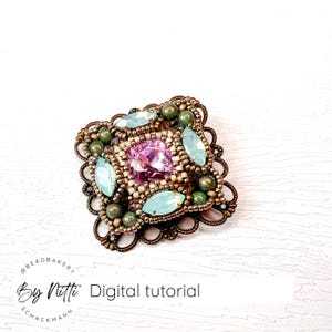 Peut inclure: Une broche carrée en perles avec un cristal rose au centre, entouré de perles bleu clair et vertes. La broche est sertie dans un cadre en métal de couleur bronze avec un motif décoratif.