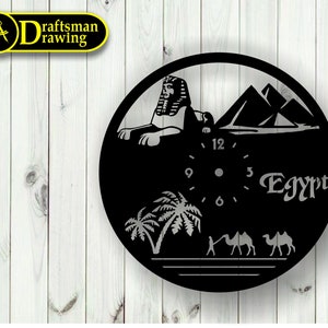 May include: Black and white clock featuring a design of the Sphinx, pyramids, palm trees, and camels. The clock face has Roman numerals and the word "Egypt" is written below the clock face.