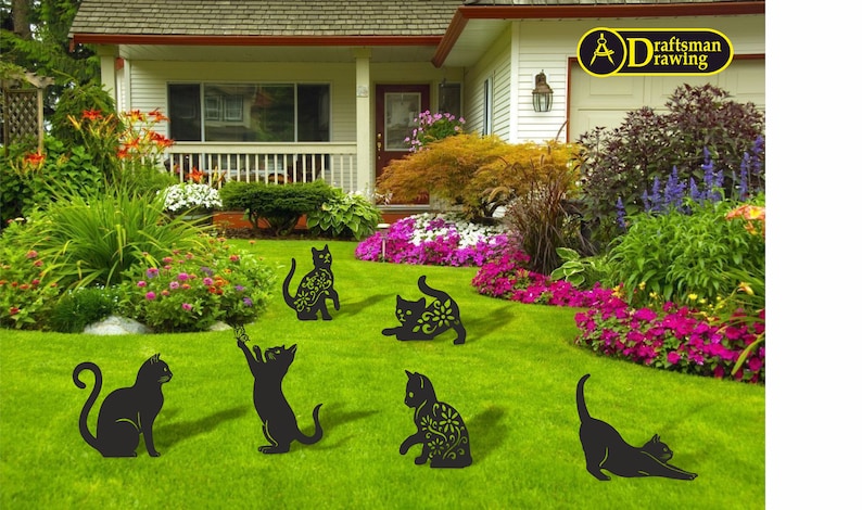 May include: Black metal cat yard art in various poses, including sitting, stretching, and playing. Some cats have floral cutouts. The cats are placed on a green lawn in front of a house with colorful flowers.