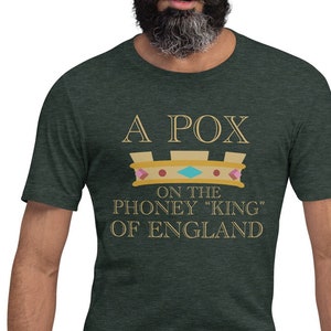 Puede incluir: Una camiseta verde con una corona dorada y el texto "A Pox on the Phoney "King" of England".