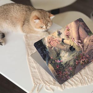 May include: A laptop skin featuring a vintage painting of two women in a garden setting. The painting depicts a floral design with pink, white and purple flowers. The skin is designed to fit a laptop.