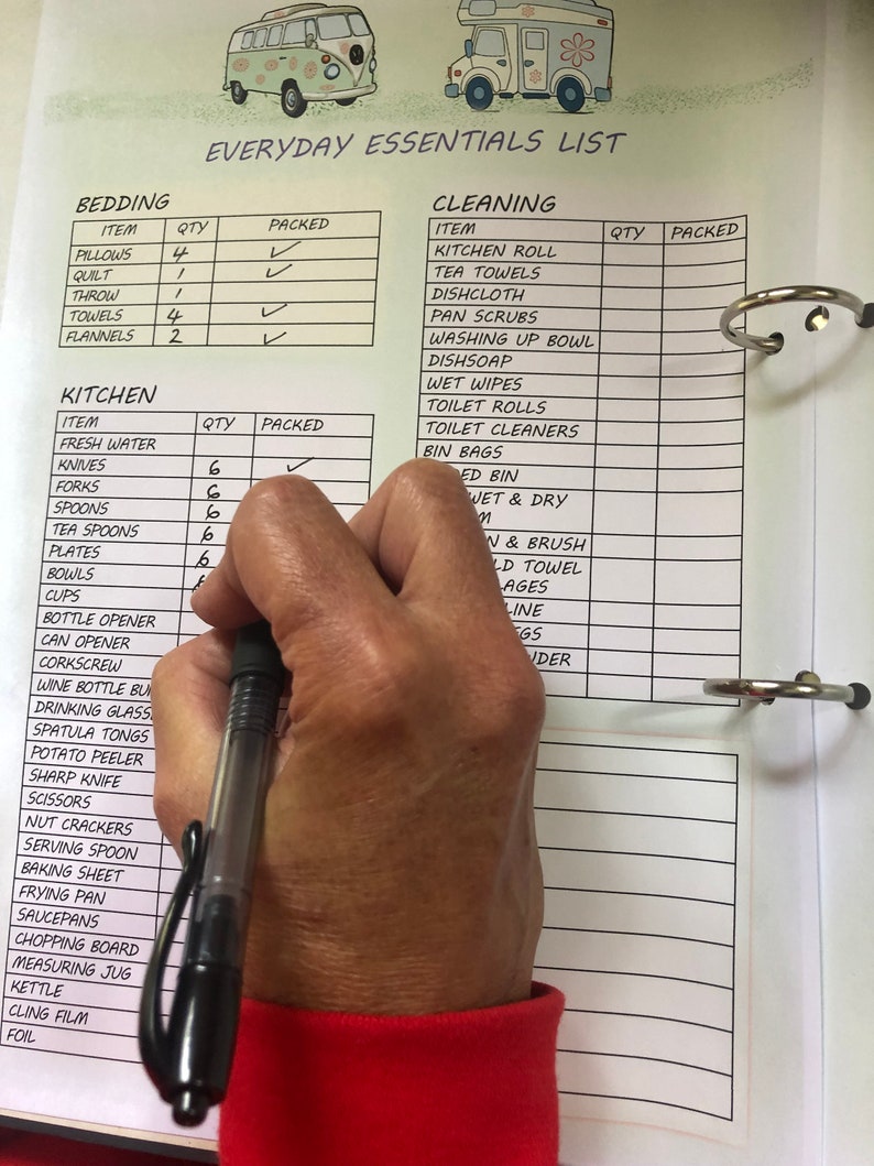 Puede incluir: Una lista de verificaci&oacute;n blanca con una ilustraci&oacute;n en blanco y negro de una camioneta vintage en la parte superior. La lista de verificaci&oacute;n se titula "Everyday Essentials List" y est&aacute; dividida en dos secciones: "Bedding" y "Cleaning". La lista de verificaci&oacute;n incluye art&iacute;culos como almohadas, una colcha, toallas, papel de cocina, toallas de t&eacute;, pa&ntilde;os de cocina y papel higi&eacute;nico. Una mano sostiene una pluma negra y marca los art&iacute;culos de la lista de verificaci&oacute;n.