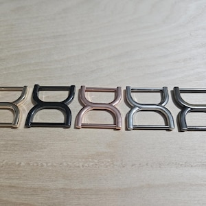 May include: Five metal hourglass-shaped buckles in different finishes: gold, black, rose gold, silver, and gunmetal.