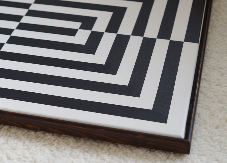 Pu&ograve; includere: Un dipinto astratto geometrico in bianco e nero su tela con una cornice in legno scuro.