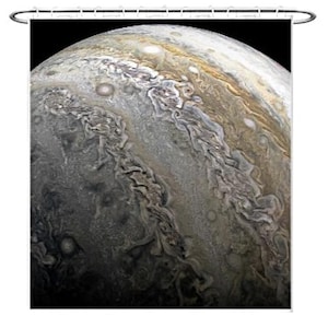May include: A close-up image of Jupiter, a gas giant with swirling clouds and a large red spot. The planet is a pale yellow and brown color with a dark, swirling storm in the center.