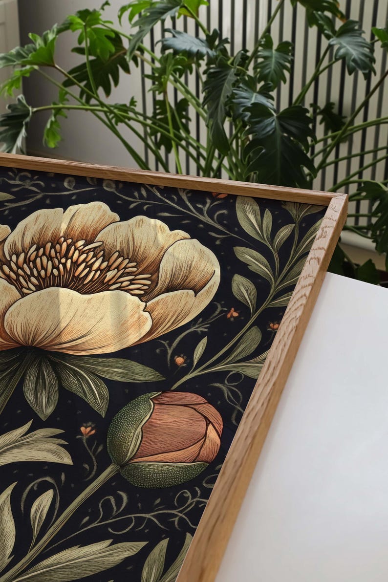 May include: A framed print with a floral pattern featuring large, light brown flowers with orange centers and green leaves on a dark blue background.