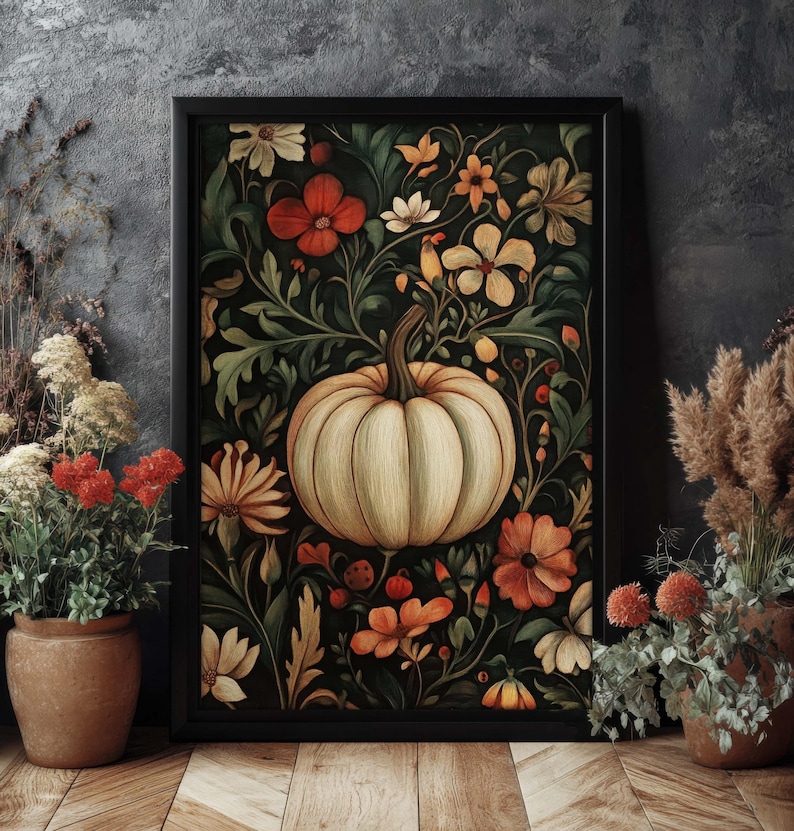 Peut inclure: Une impression d'art encadr&eacute;e repr&eacute;sentant une citrouille cr&egrave;me entour&eacute;e de fleurs orange, rouges et cr&egrave;me et de feuillage vert. L'&oelig;uvre d'art a un fond sombre et est encadr&eacute;e dans un cadre noir. Le th&egrave;me g&eacute;n&eacute;ral est l'automne et la r&eacute;colte.