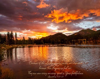 May include: A scenic landscape photograph of a lake at sunset. The sky is filled with vibrant orange and yellow hues, reflecting on the water's surface. Dark mountains and trees frame the scene. Text reads, "Because of the Lord's mercies..."