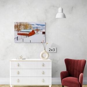 May include: A red barn with a white roof sits on a snowy field with trees in the background. The barn is surrounded by a white fence. The image is labeled "2x3" in the bottom right corner.