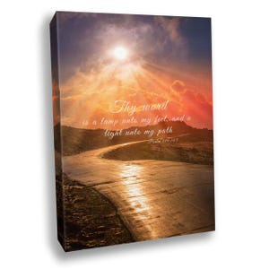 May include: A rectangular canvas wall art print featuring a sunset landscape with a winding road. The sky is filled with orange and purple clouds and a bright sun. The text reads: Thy word is a lamp unto my feet, and a light unto my path Psalm 119:105.