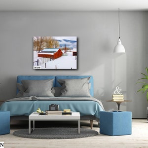 May include: A red barn with a white roof sits in a snowy field. The barn is surrounded by trees and a fence. The image is a 30x40 inch print.