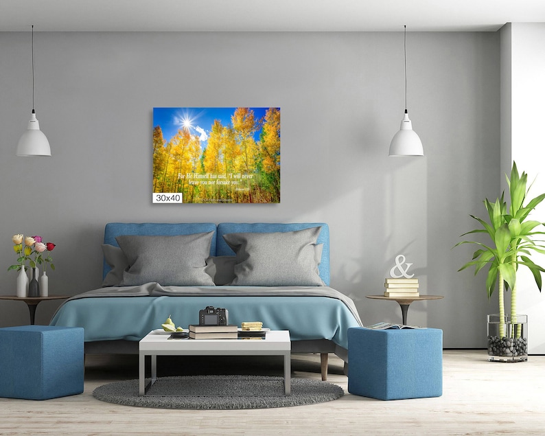 Może przedstawiać: Wydruk na pł&oacute;tnie o wymiarach 76x102 cm przedstawia jesienny krajobraz. Grafika przedstawia wysokie drzewa z ż&oacute;łtymi liśćmi na tle błękitnego nieba i jasnego słońca. Tekst jest widoczny na wydruku.
