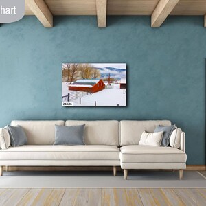 May include: A white couch with pillows sits in front of a blue wall with a framed photograph of a red barn in a snowy landscape. The text "24X36 IN" is visible in the bottom left corner of the image.
