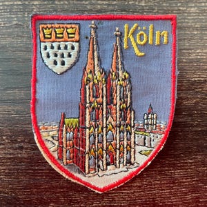 Könnte beinhalten: Ein Set aus drei Keramikbechern mit gesprenkelter, matter Oberfläche. Die Becher sind in den Farbtönen Creme, Hellgrau und Dunkelgrau gehalten. Jeder Becher hat ein schlichtes, minimalistisches Design, ideal für Kaffee oder Tee.