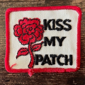 Op de afbeelding: Een witte keramische mok met een zwart handvat en de tekst "But First, Coffee" in een vetgedrukte, zwarte letter. De mok staat tegen een vage achtergrond. De mok is ongeveer 10 cm hoog.