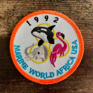Vintage patch Marine World California: Geborduurd reissouvenir uit de jaren 90 met orka en flamingo.